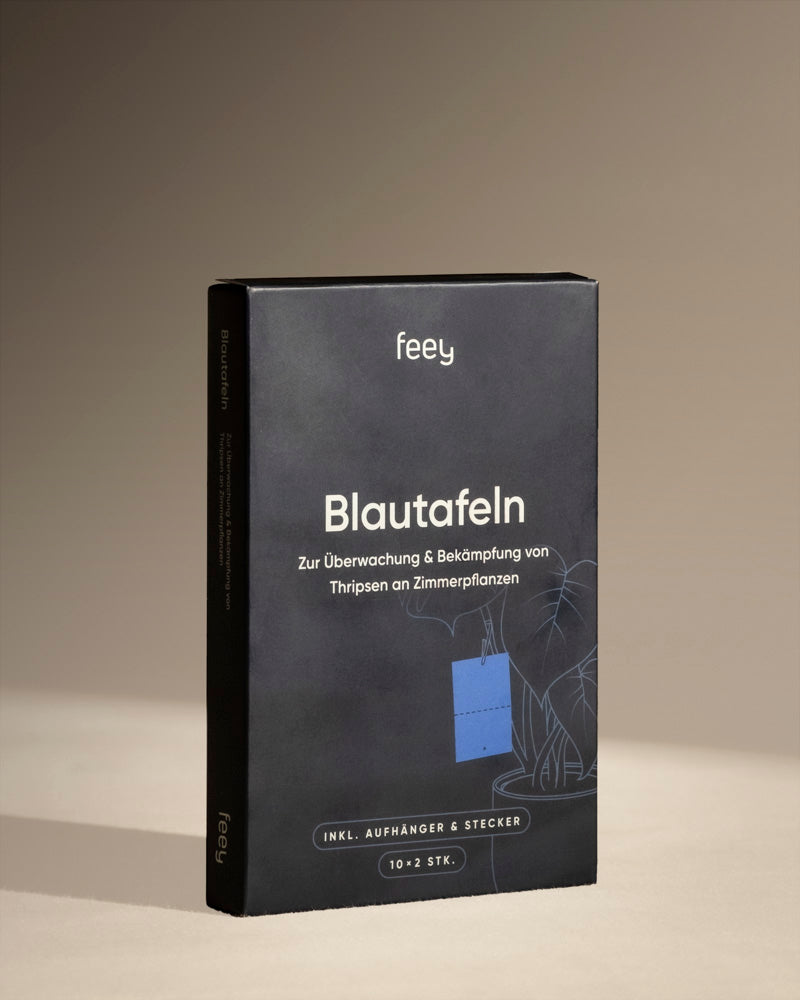 Eine schwarze Box mit der Aufschrift „Blautafeln gegen Thripse“ von Feey, mit dem Bild einer blauen Klebefalle und einer Zimmerpflanze, die zur Überwachung und Kontrolle von Thripsen und Schädlingsbefall bei Zimmerpflanzen entwickelt wurde.
