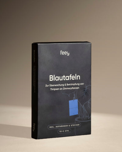 Eine schwarze Box mit der Aufschrift „Blautafeln gegen Thripse“ von Feey, mit dem Bild einer blauen Klebefalle und einer Zimmerpflanze, die zur Überwachung und Kontrolle von Thripsen und Schädlingsbefall bei Zimmerpflanzen entwickelt wurde.