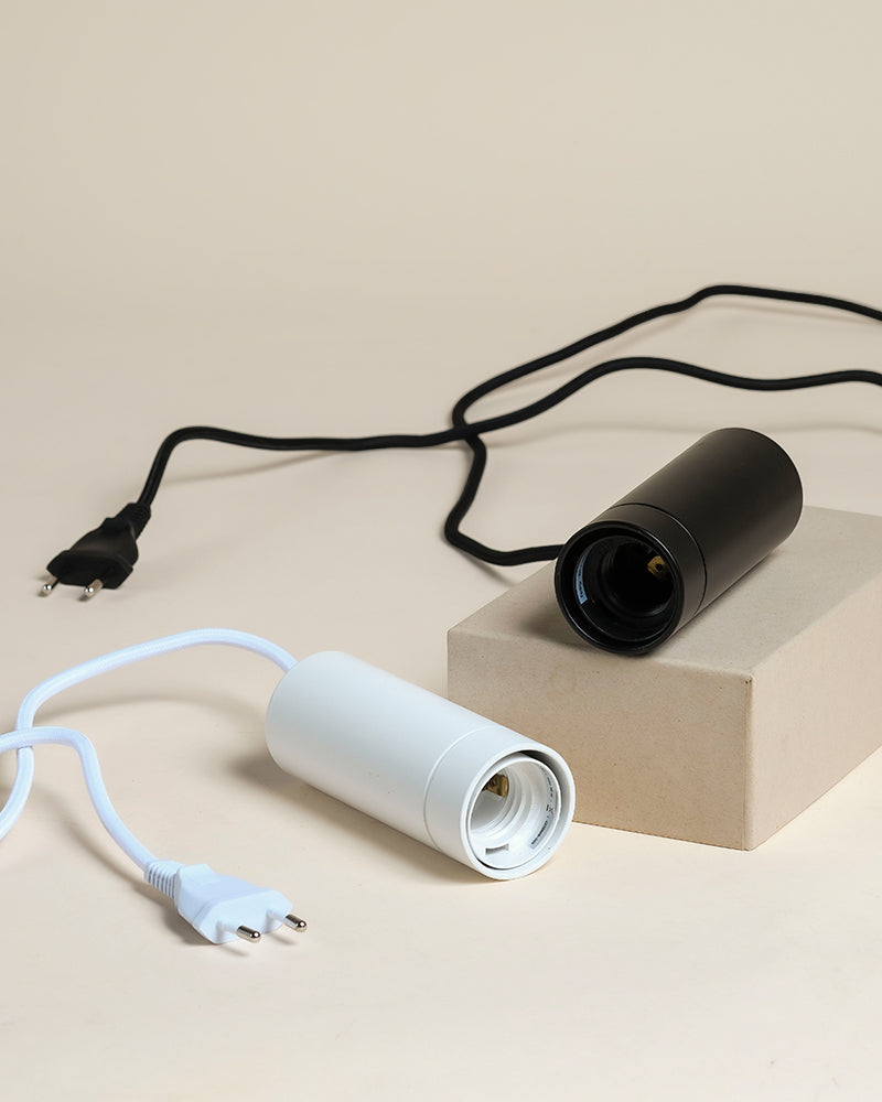 Die Pendelleuchte 'Corda' verfügt über zwei zylindrische Fassungen - eine schwarze mit einer Kordel auf einem Kasten, und eine weiße daneben - auf beige, perfekt für Zimmerpflanzen-Fans oder als stilvolle Pflanzenlampe.