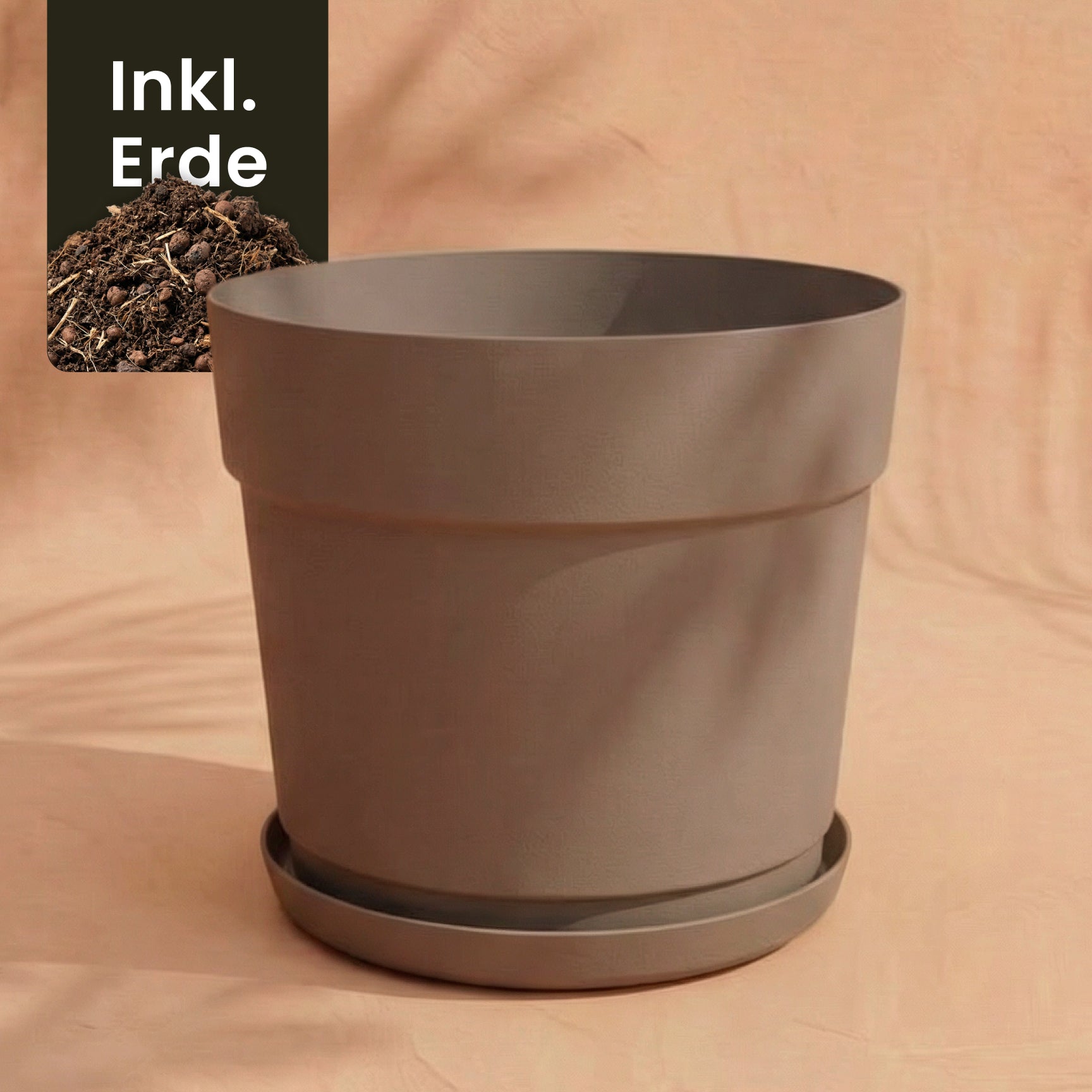 Ein großer, schlichter Kunststoff Pflanzkübel (Bloom | 29 cm Ø) aus recyceltem Material mit passender Untertasse steht auf neutralem Grund. Oben links liegt Erde mit dem Hinweis 