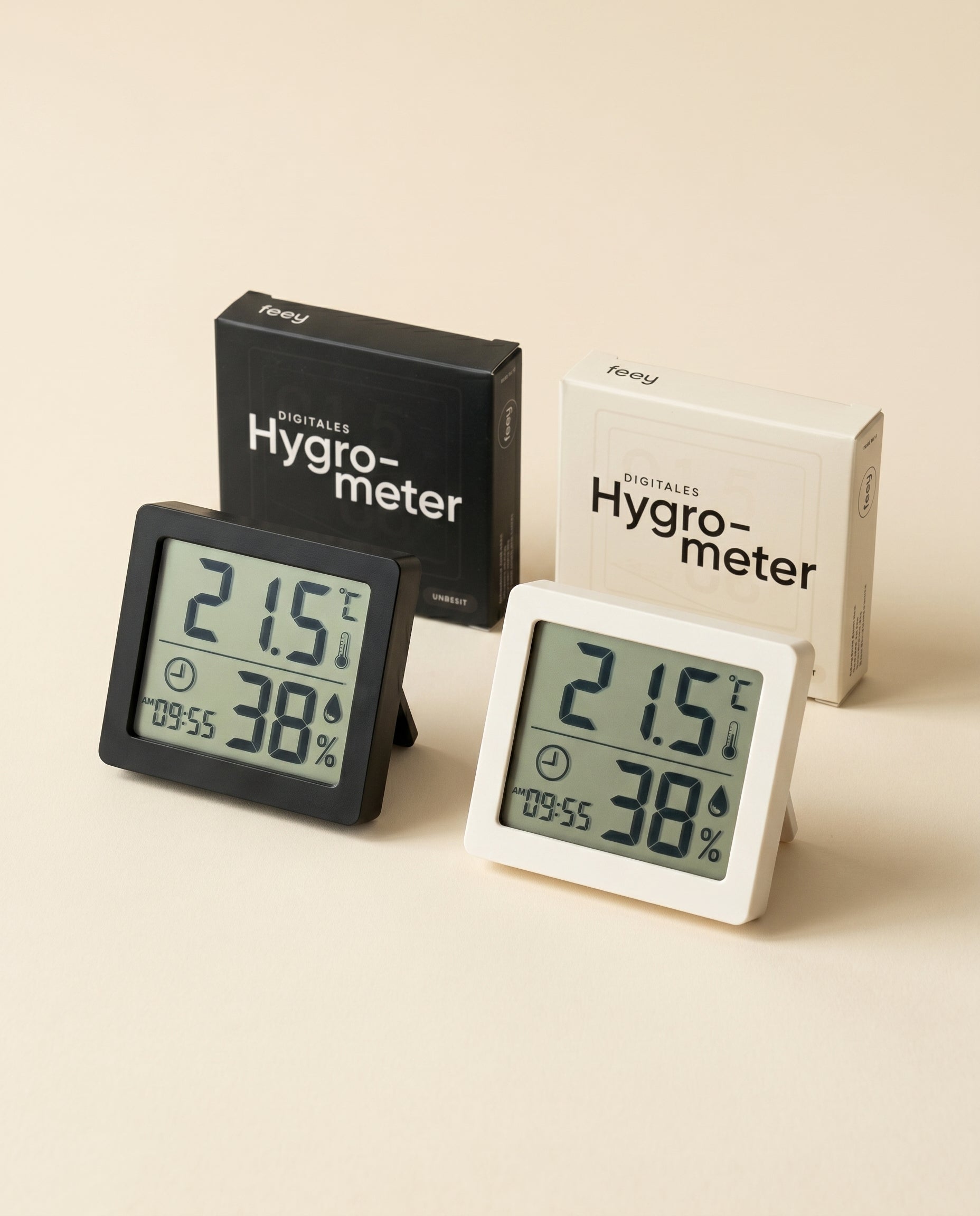 Zwei Hygrometer in Schwarz und Weiß, ideal für Zimmerpflanzen, zeigen 21,5°C und 38% Luftfeuchtigkeit an. Vor ihnen stehen passende Boxen mit der Aufschrift 