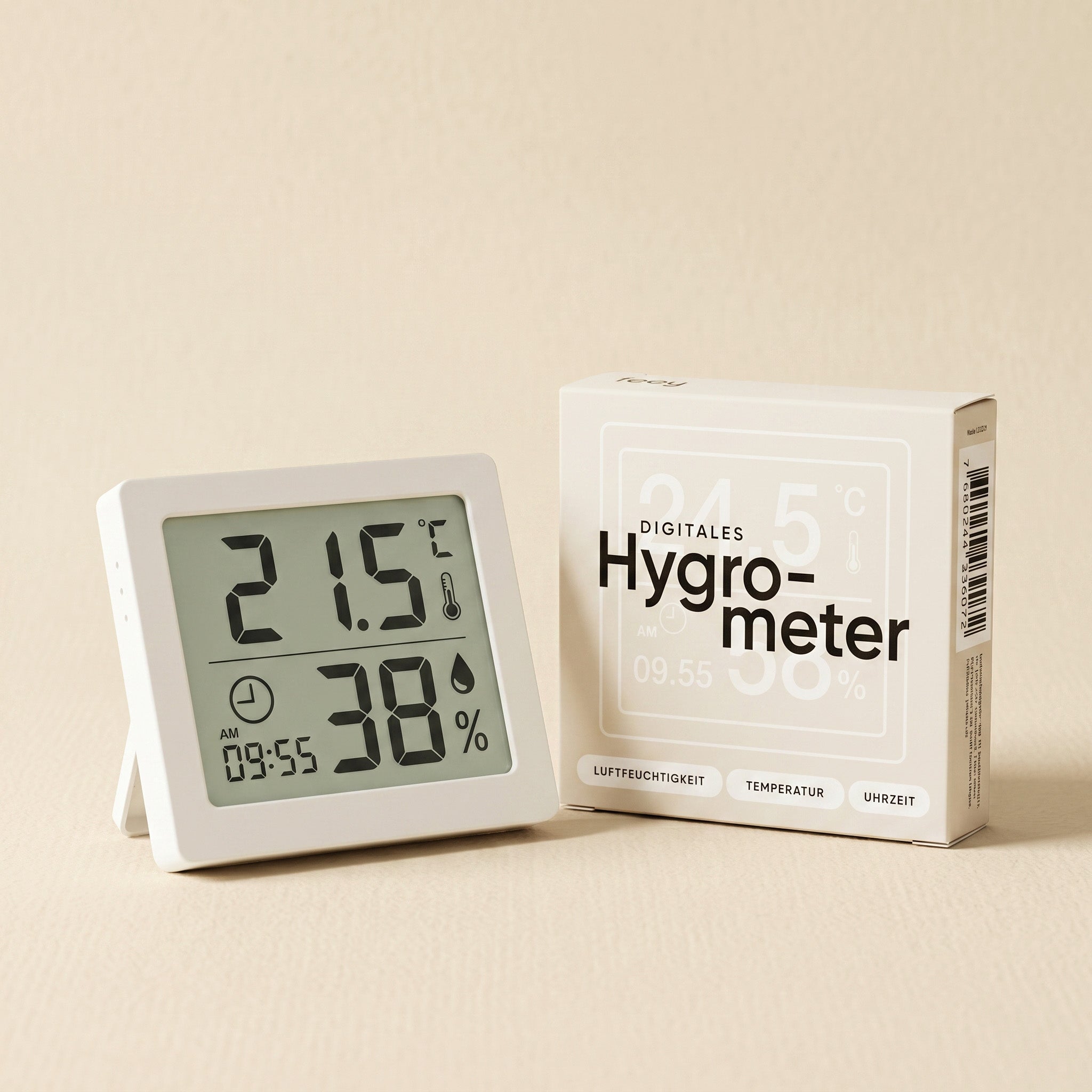 Ein digitales Hygrometer zeigt 21,5°C und 38% Luftfeuchtigkeit neben dem weißen Kasten mit der Aufschrift 