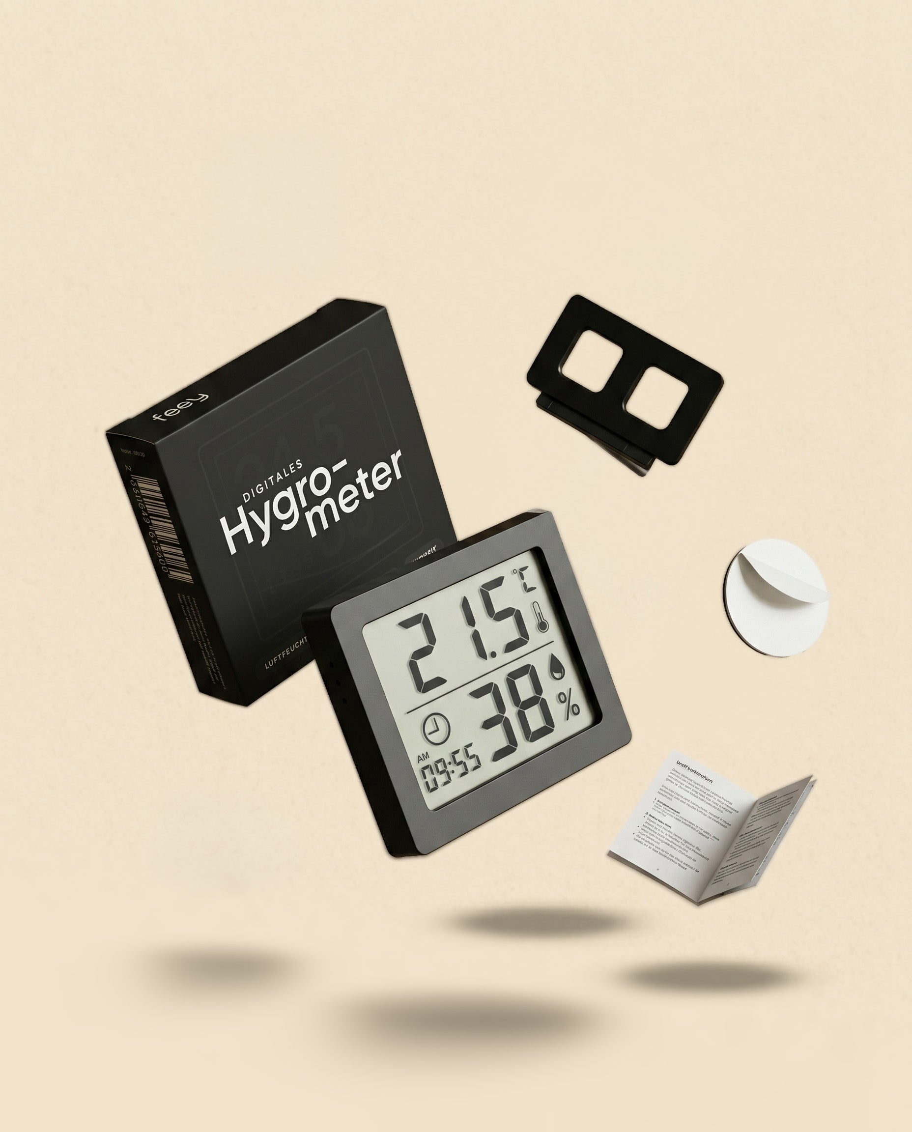 Das Hygrometer, das perfekt für Zimmerpflanzen geeignet ist, wird mit seiner Box, der Halterung, dem Klebepad und der Bedienungsanleitung auf einem beigen Hintergrund präsentiert. Der Bildschirm zeigt 21,5°C und 38% Luftfeuchtigkeit an.