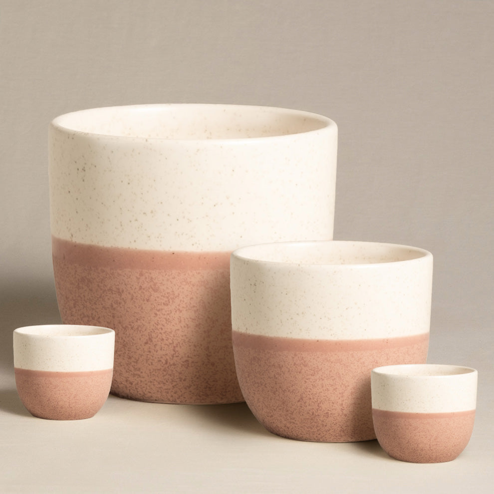 Das Keramik-Topfset „Variado“ (22, 14, 2 × 7) besteht aus vier handgefertigten Keramiktöpfen mit gesprenkeltem creme- und rosabraunem Design. Die Töpfe sind vor einem schlichten Hintergrund angeordnet und haben unterschiedliche Größen, vom größten hinten bis zum kleinsten vorne – ideal für die Präsentation von Zimmerpflanzen.