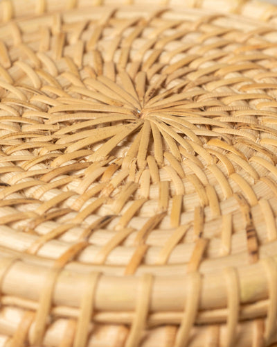 Die Nahaufnahme des Pflanzenkorbs aus Rattan (Calen | 22 cm Ø) hebt seine handgewebten, kreisförmigen Muster und die natürlichen Beige- und Hellbrauntöne hervor – ideal, um Ihrer Pflanzenpräsentation Stil zu verleihen.