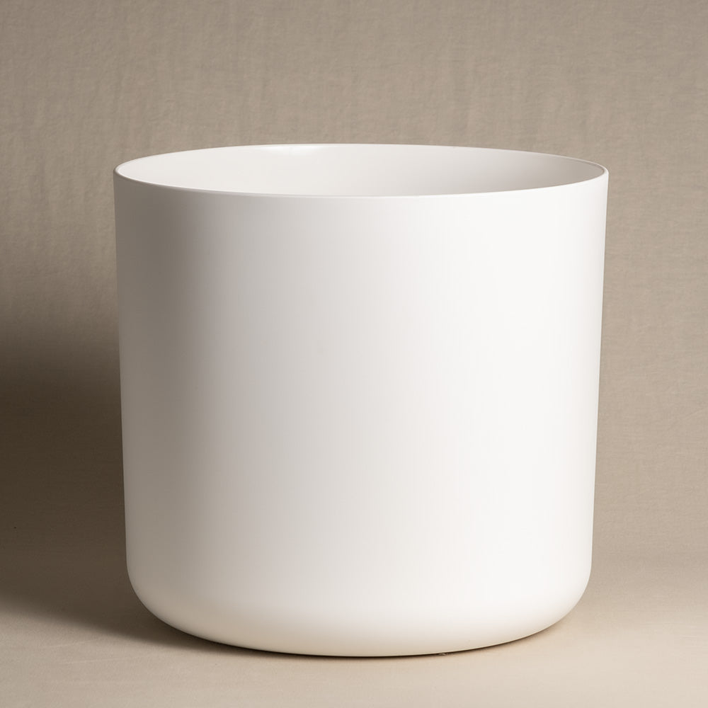 Ein minimalistischer, mattweißer zylindrischer **Kunststoff-Topf (Soft | 35 cm ⌀)** aus recyclebarem Kunststoff mit glatter Oberfläche steht vor einem schlichten beigen Hintergrund. Der Topf hat leicht abgerundete Kanten an der Basis und eine gerade, offene Oberseite. Das Design ist schlicht und modern.
