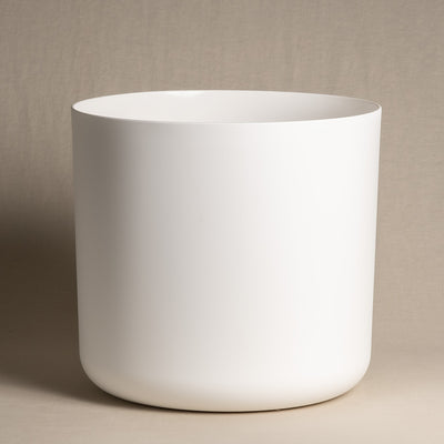 Ein minimalistischer, mattweißer zylindrischer **Kunststoff-Topf (Soft | 35 cm ⌀)** aus recyclebarem Kunststoff mit glatter Oberfläche steht vor einem schlichten beigen Hintergrund. Der Topf hat leicht abgerundete Kanten an der Basis und eine gerade, offene Oberseite. Das Design ist schlicht und modern.
