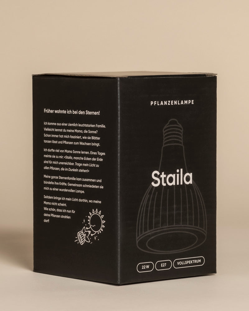 Ein schwarzer Karton mit einer Pflanzenlampe, einem umrandeten Leuchtmittel, deutschem Text und Symbolen. Die Box hebt 22W Leistung, E27 Sockel und Vollspektrum hervor - ideal für Zimmerpflanzen, die Sonnenlicht benötigen.