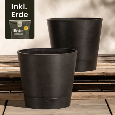 Das Bild zeigt zwei große, schwarze Pflanzkübel-Set Venice (2x 30) von EcoPots, die auf einer Holzoberfläche platziert sind. In der oberen linken Ecke ist ein kleineres Bild eines Sacks Erde mit dem Text „Inkl. Erde“ zu sehen. Die Töpfe verfügen wahrscheinlich über ein integriertes Drainage-System.