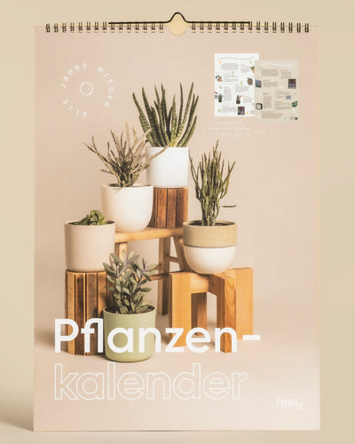 Der Wandkalender "Pflanzenkalender" zeigt acht Topfpflanzen auf Holzständern in Beige, mit einer Innenseitenvorschau - ein idealer immerwährender Kalender und Geschenk für Pflanzenfans.