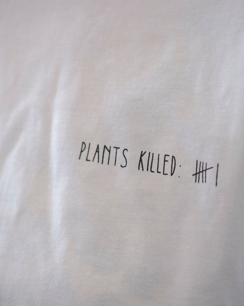 Detailaufname eines weißen T-Shirts mit dem Aufdruck «Plants Killed»