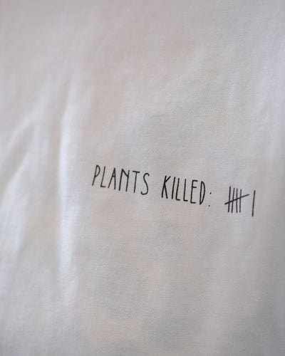 Detailaufname eines weißen T-Shirts mit dem Aufdruck «Plants Killed»