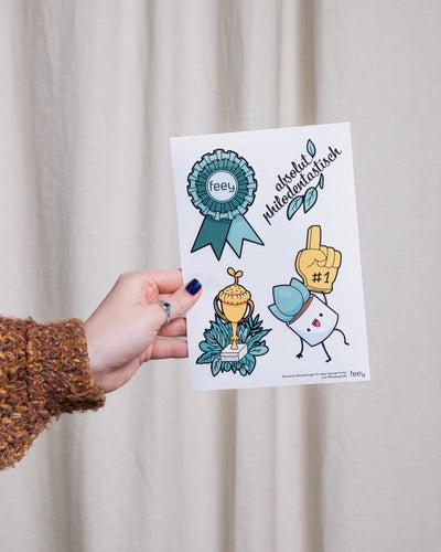 Der Quiz-Stickerbogen von feey wird hochgehalten.