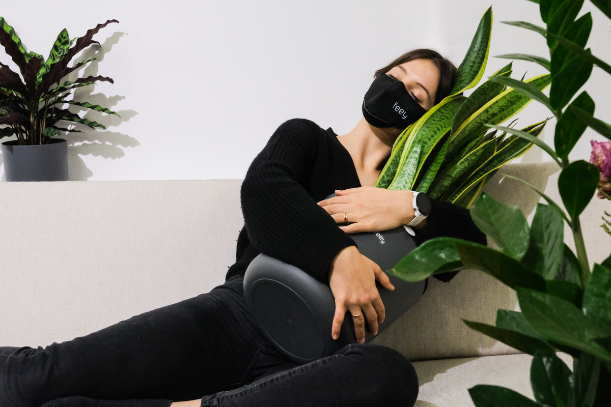 Pflanzenliebe ist Selbstliebe Pflanzenliebe ist Selbstliebe: Eine Frau liegt auf dem Sofa und umarmt eine grosse Sansevieria
